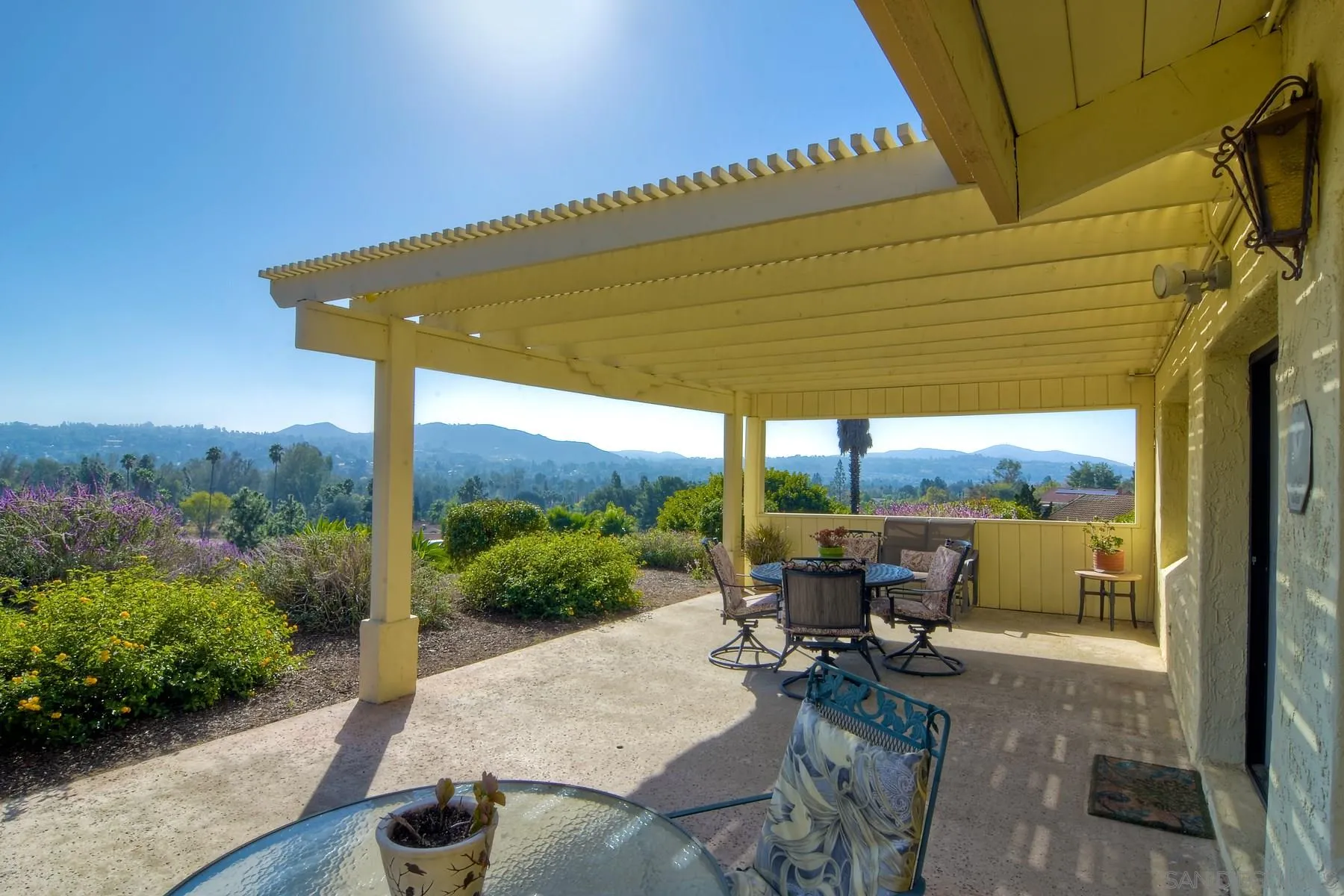 a view of a patio with table and chairs under an umbrella