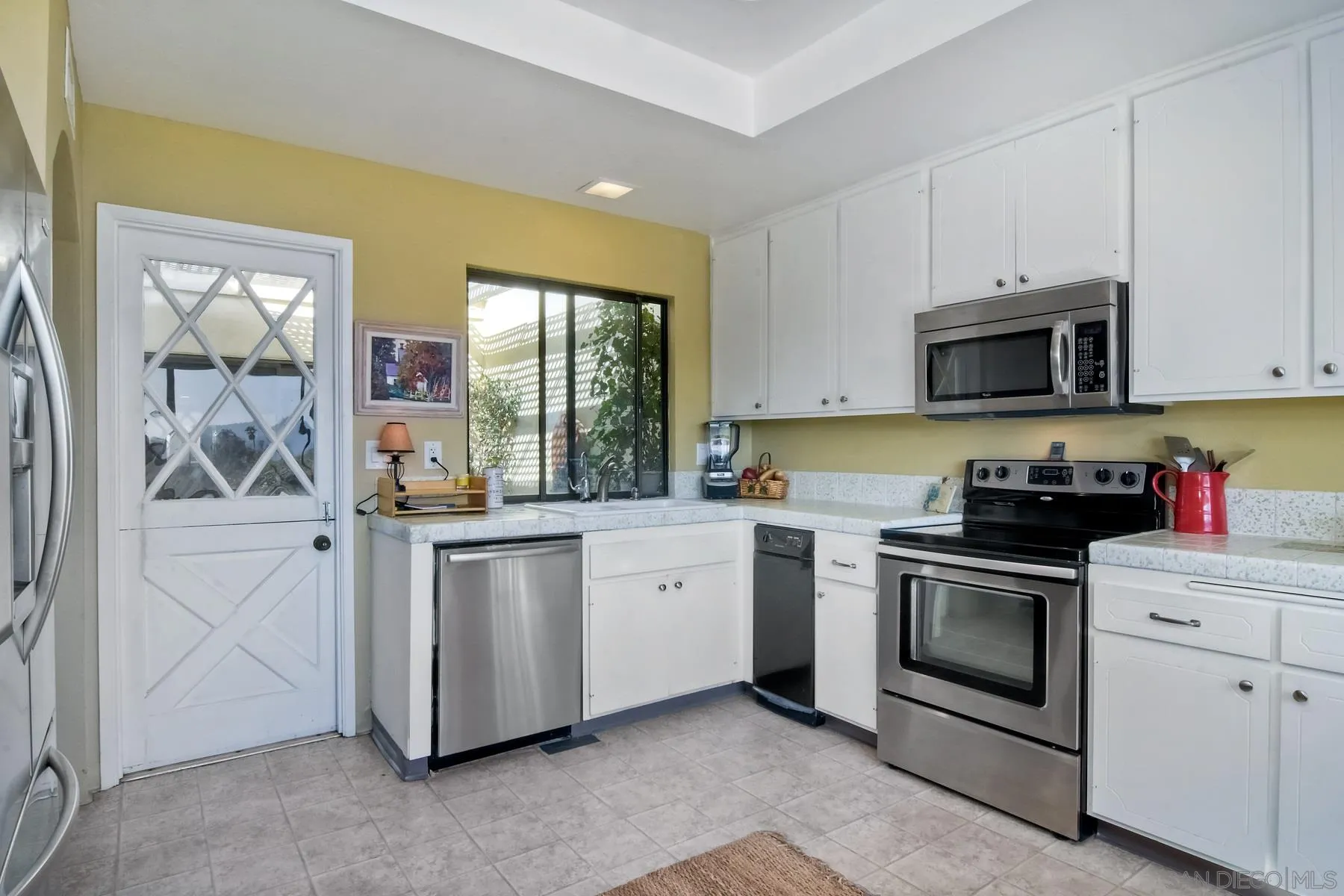 13416 The Square Poway, CA 92064 - Photo 17 of 35 a kitchen with white cabinets and appliances