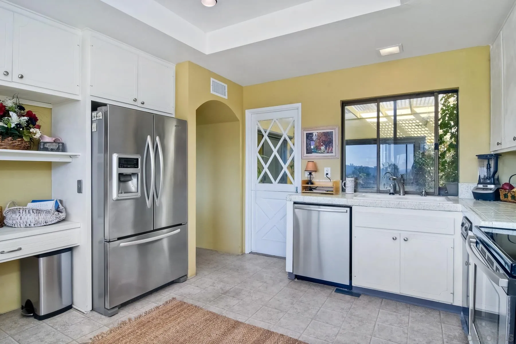 13416 The Square Poway, CA 92064 - Photo 21 of 35 a kitchen with stainless steel appliances a refrigerator sink and cabinets