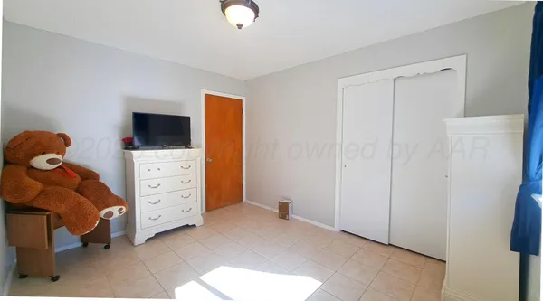 a room with baby crib and dresser