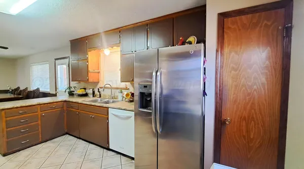 a kitchen with stainless steel appliances granite countertop a refrigerator and a sink