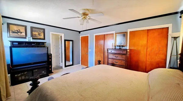 a bedroom with a bed dresser and a flat tv screen