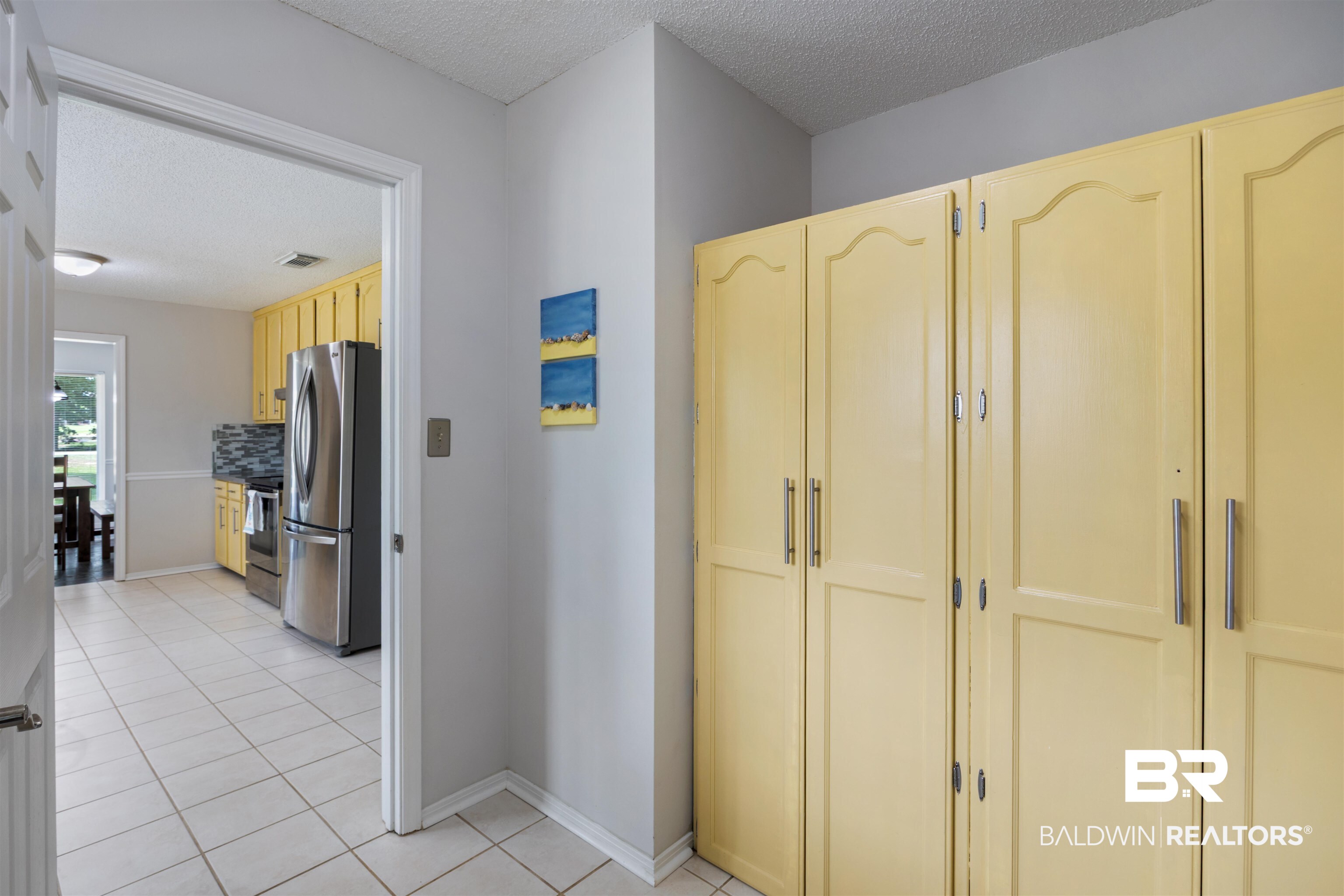 9771 Clarke Ridge Road Foley, AL 36535 - Photo 40 of 72 Hallway with a textured ceiling, baseboards, and light tile patterned flooring.