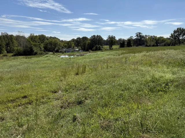 a view of a golf course with an outdoor space and seating
