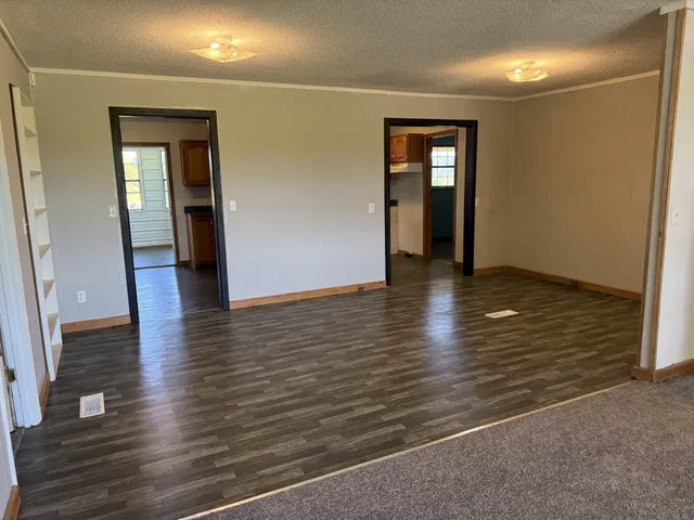 an empty room with wooden floor and entrance