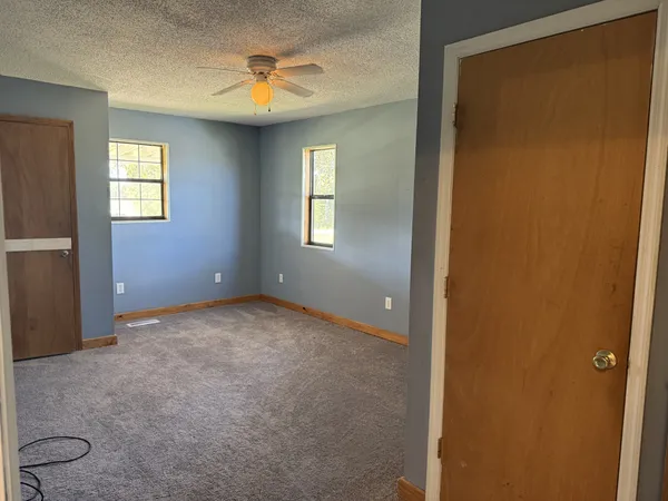 a kitchen with stainless steel appliances granite countertop a refrigerator a sink dishwasher a stove and white countertops with wooden floor