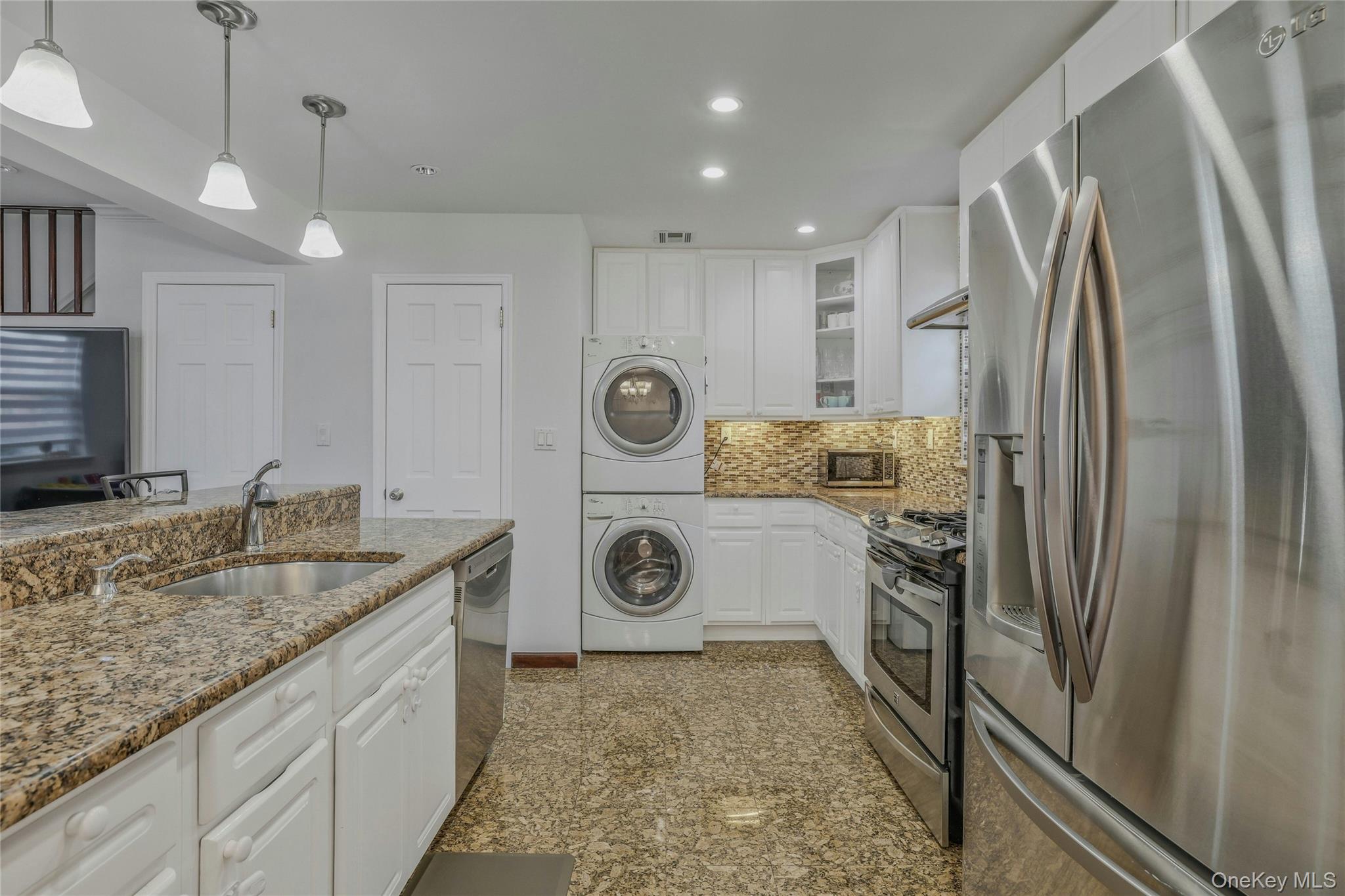 22904 67th Avenue, Unit 38 Queens, NY 11364 - Photo 6 of 17 a bathroom with a granite countertop sink and a refrigerator