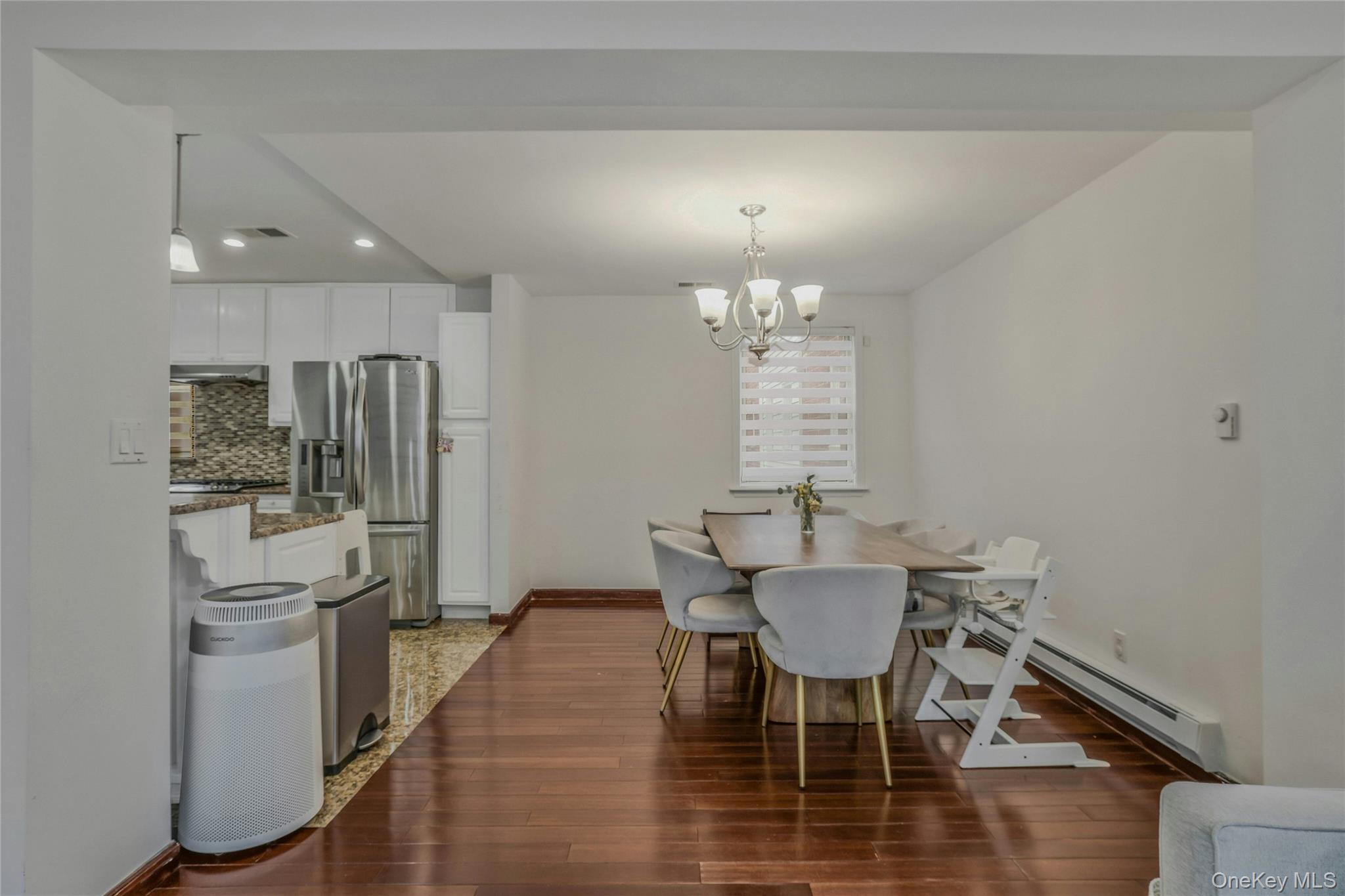 22904 67th Avenue, Unit 38 Queens, NY 11364 - Photo 8 of 17 a view of a dining room with furniture a chandelier and wooden floor