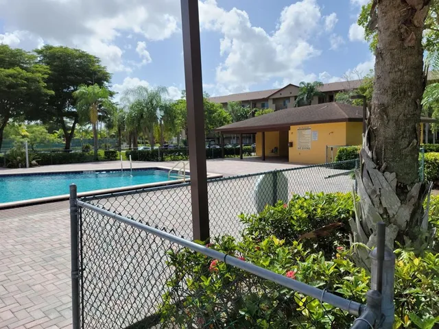 a view of a swimming pool with a patio and a yard