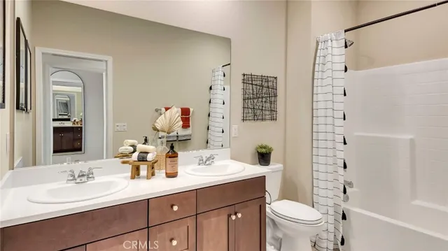 a bathroom with a double vanity sink mirror and toilet