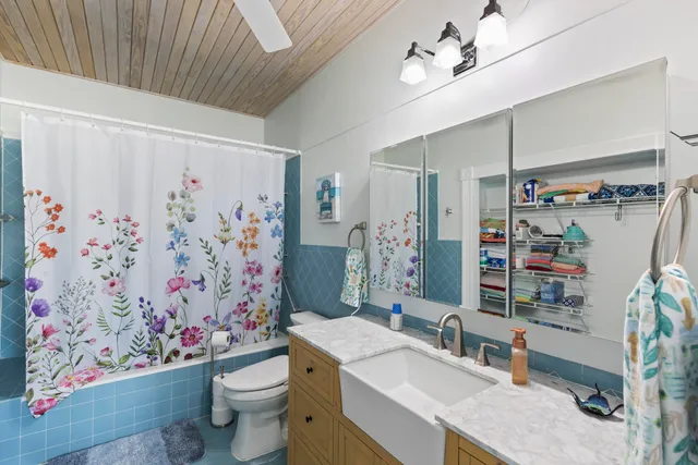 a bathroom with a sink toilet and shower curtain