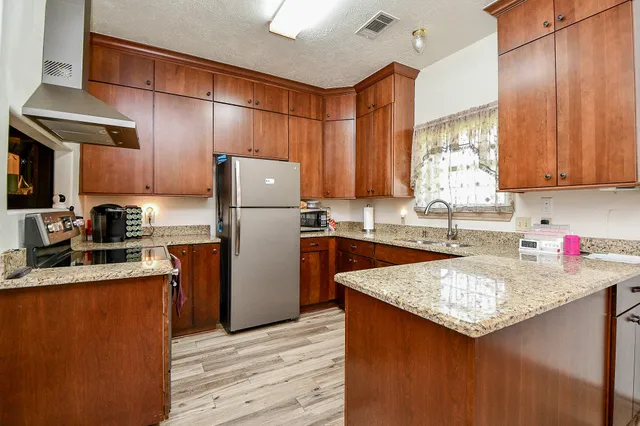 a kitchen with a refrigerator a sink and wooden cabinets