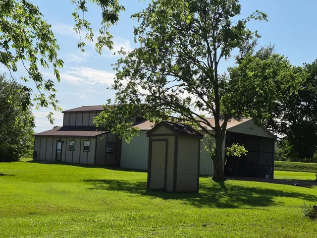 a view of a house with a big yard and large trees