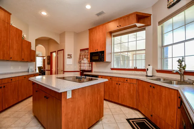 a kitchen with stainless steel appliances granite countertop a sink stove and cabinets