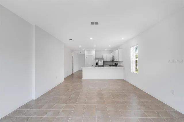 a view of kitchen with kitchen island white cabinets and refrigerator