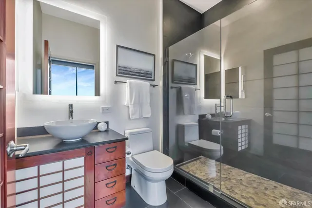 a view of bathroom with a toilet sink and mirror