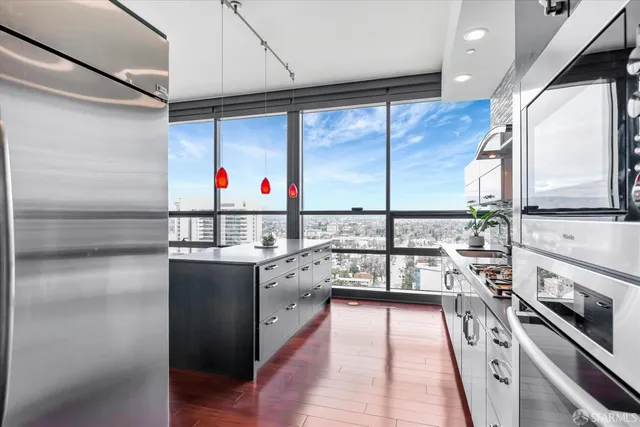 a kitchen with stainless steel appliances granite countertop a sink cabinets and wooden floor