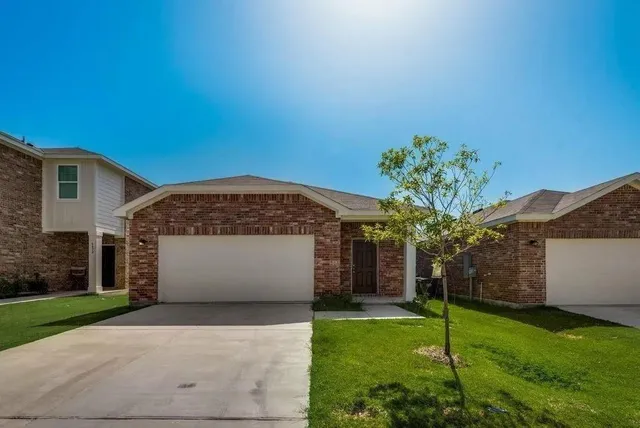 a front view of a house with a yard and a garage