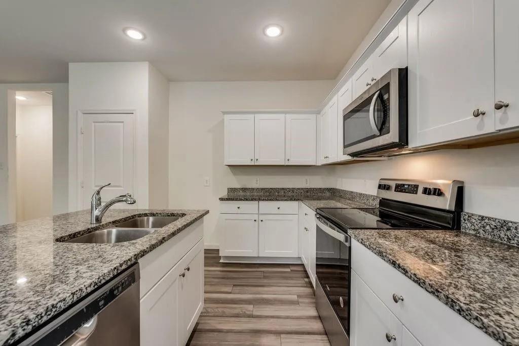 6830 Bonanza Way Forney, TX 75126 - Photo 3 of 14 a kitchen with granite countertop cabinets stainless steel appliances and a sink