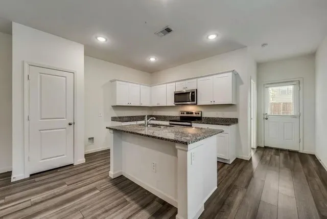 a kitchen with stainless steel appliances granite countertop a stove and a refrigerator