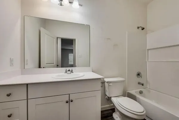 a bathroom with a sink toilet vanity and shower