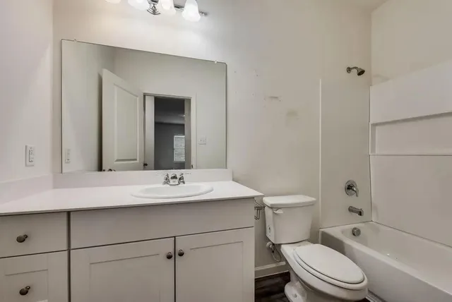 a bathroom with a sink toilet vanity and shower