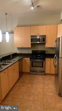 1209 North Charles Street, Unit 302 Baltimore, MD 21201 - Photo 11 of 25 a kitchen with stainless steel appliances a sink and a microwave