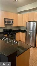 1209 North Charles Street, Unit 302 Baltimore, MD 21201 - Photo 12 of 25 a kitchen with a sink and a refrigerator