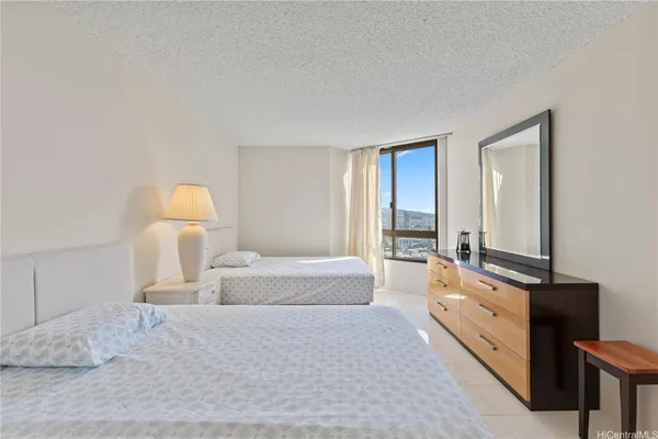 a spacious bedroom with a bed and a lamp