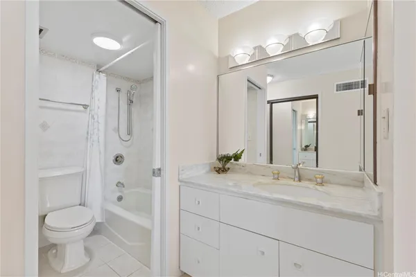 a bathroom with a granite countertop sink toilet a shower and a mirror