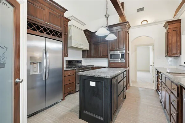 a kitchen with stainless steel appliances granite countertop a stove a refrigerator and a sink