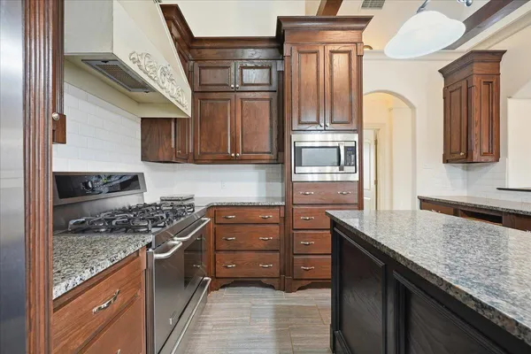 a kitchen with stainless steel appliances granite countertop a stove sink and cabinets