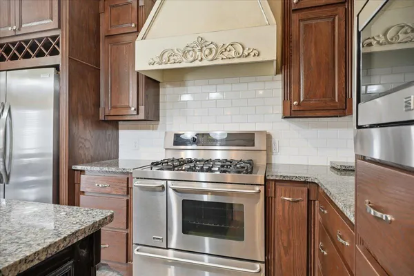 a kitchen with stainless steel appliances granite countertop a stove and a refrigerator