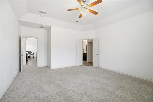 a view of a room with a ceiling fan and a bathroom