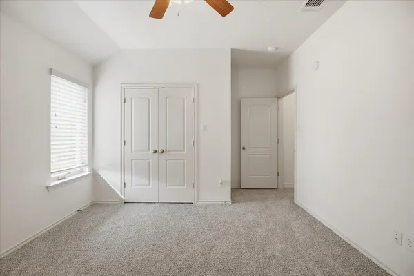 an empty room with windows and closet