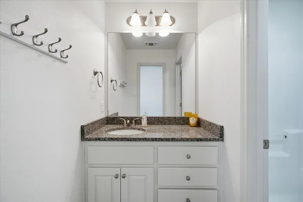 a bathroom with a granite countertop sink and a mirror