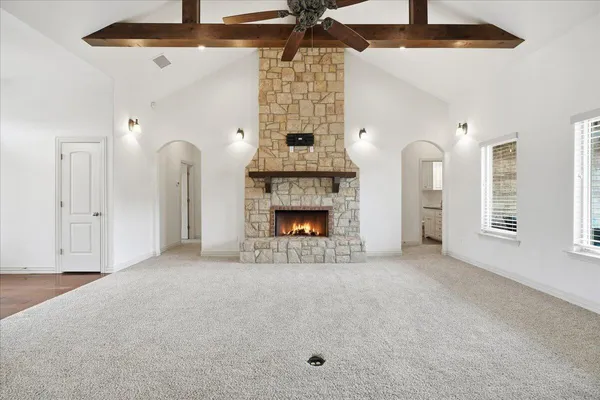 a view of an empty room with a fireplace and a window
