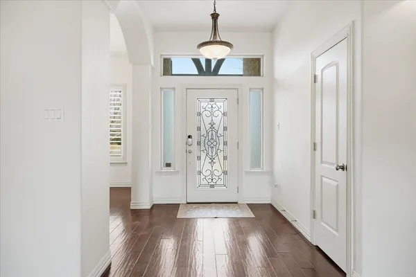 a view of a hallway with wooden floor and entryway