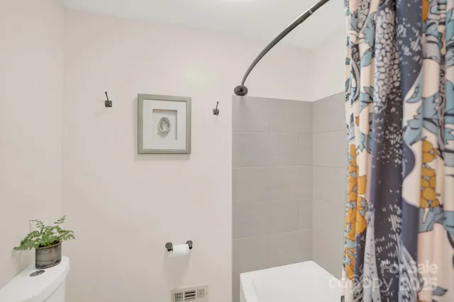 a bathroom with a toilet and a shower curtain