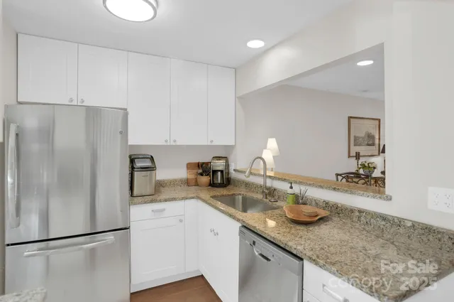a kitchen with stainless steel appliances granite countertop a sink refrigerator and microwave