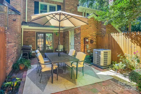 a view of a patio with a table and chairs under an umbrella