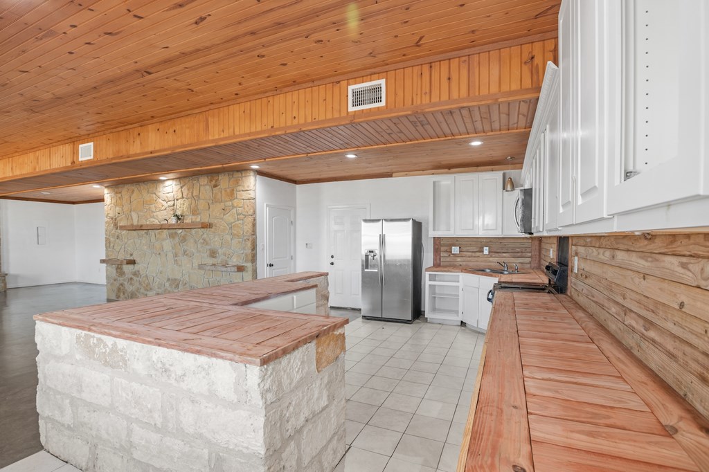 288.000000 Kroll Road Harper, TX 78631 - Photo 12 of 49 a kitchen with refrigerator and cabinets