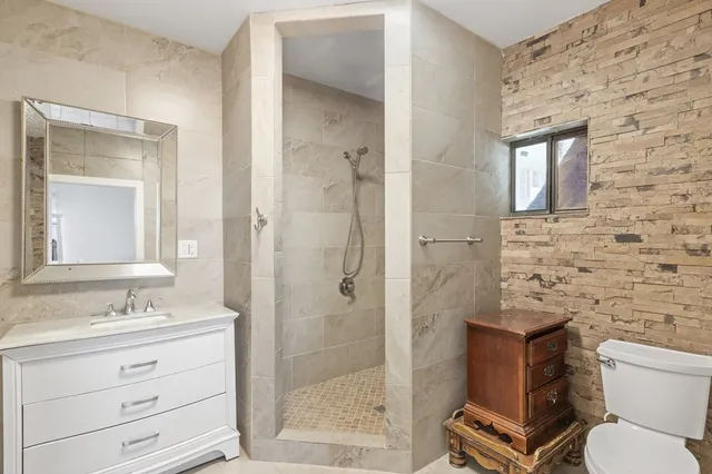 a bathroom with a shower sink vanity and mirror