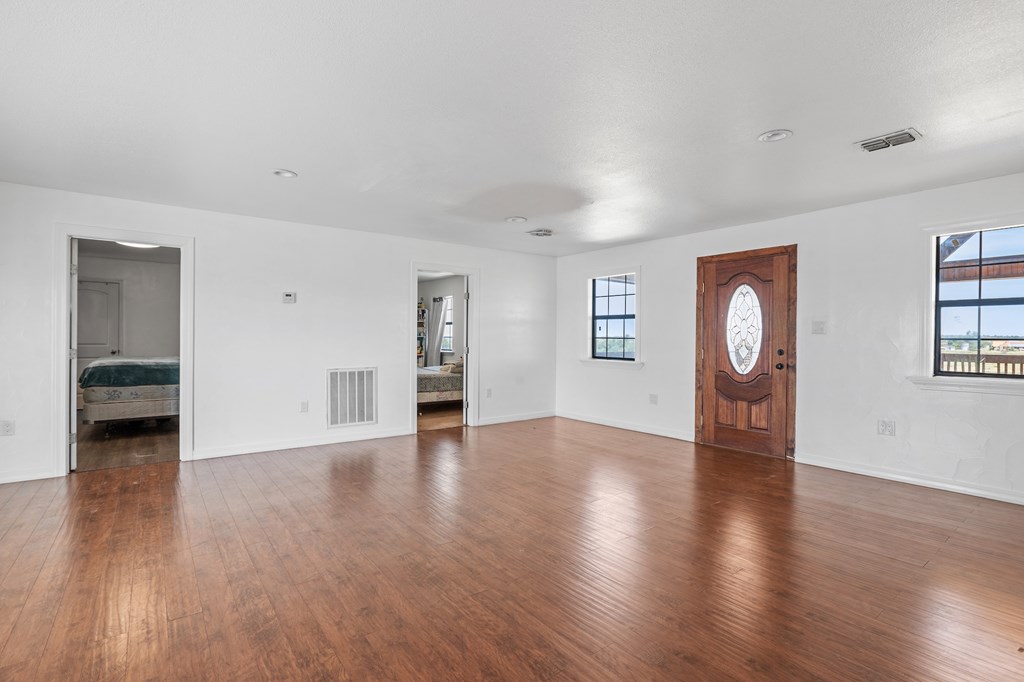 288.000000 Kroll Road Harper, TX 78631 - Photo 22 of 49 an empty room with wooden floor and windows