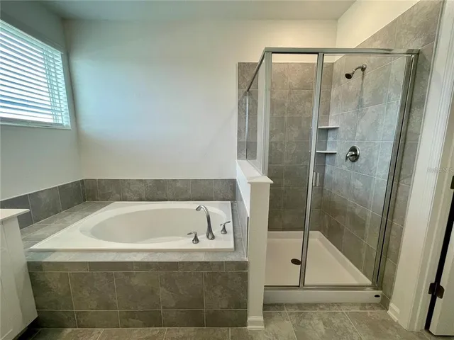 a spacious bathroom with a tub sink and mirror