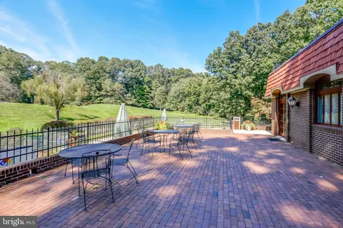 a view of a patio with couches and table potted plants and floor to ceiling window