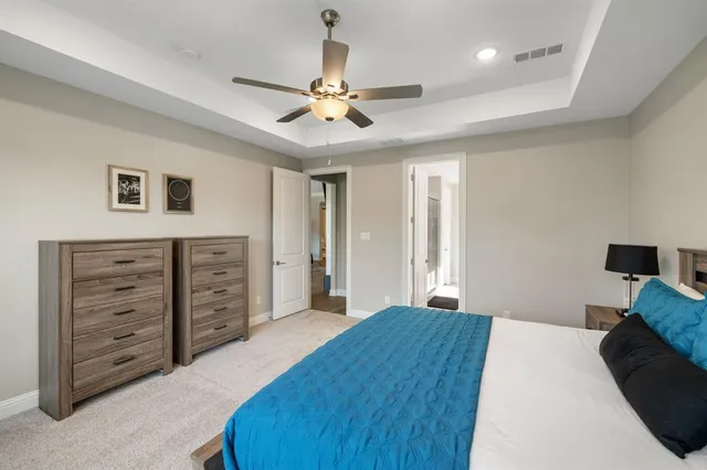 a bedroom with a large bed and a chandelier
