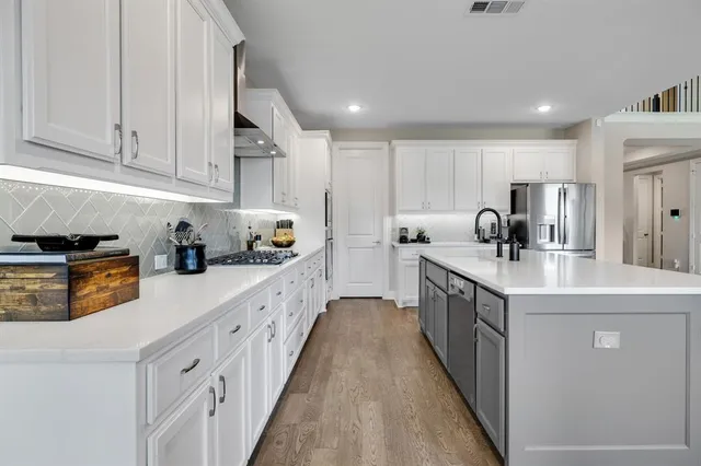 a kitchen with stainless steel appliances granite countertop a sink and cabinets