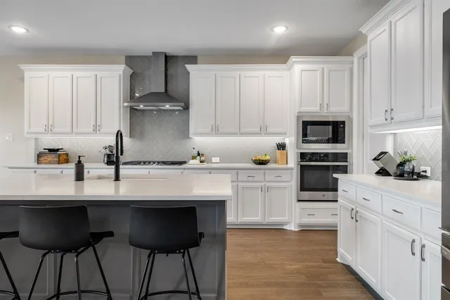 a kitchen with stainless steel appliances kitchen island granite countertop a sink and cabinets