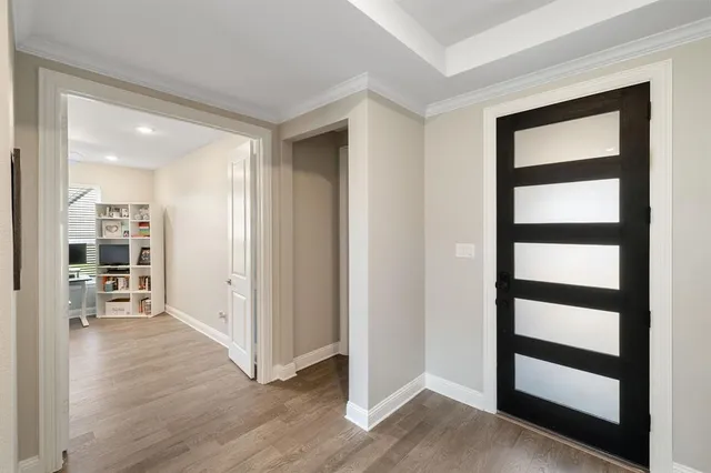 a view of a hallway with wooden floor and windows